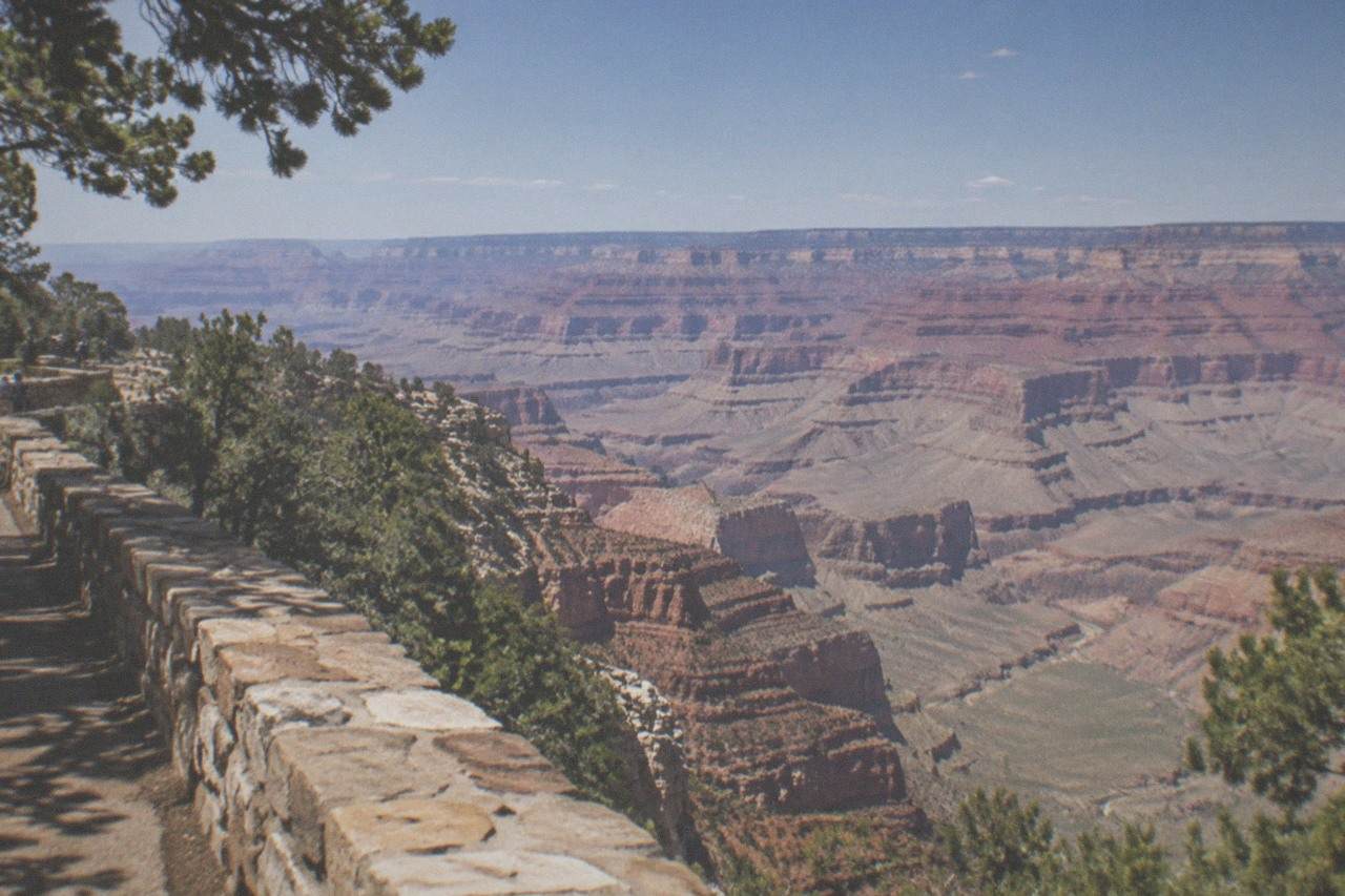 Grand Canyon South Rim at midday with layered rock walls above a wide canyon floor