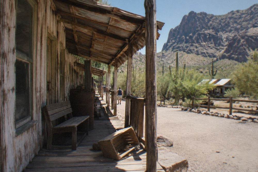 Old west style wooden storefront of the Tortilla Flat country store beneath desert cliffs