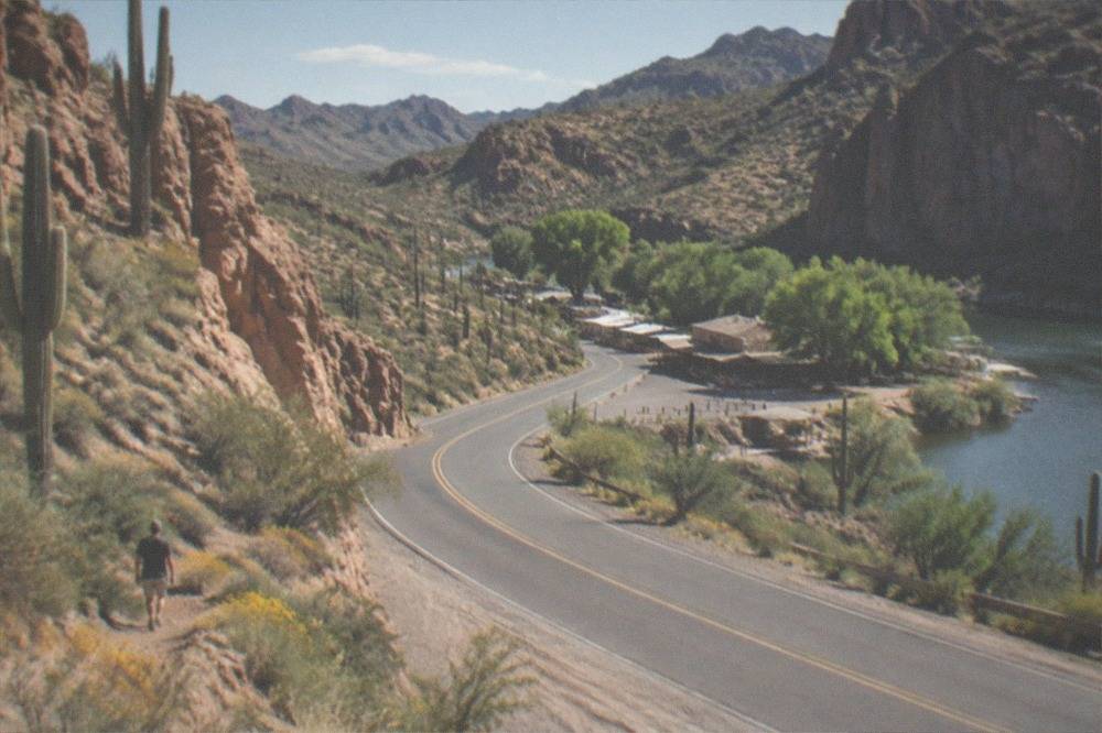 Winding paved desert road approaching Tortilla Flat between rock formations