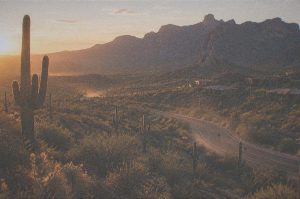 Golden evening light on desert hills with a winding paved road below