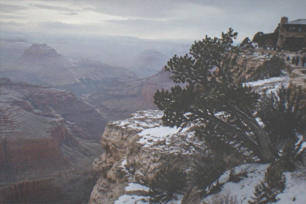 Grand Canyon South Rim in winter with light snow on the rock ledges and haze in the canyon