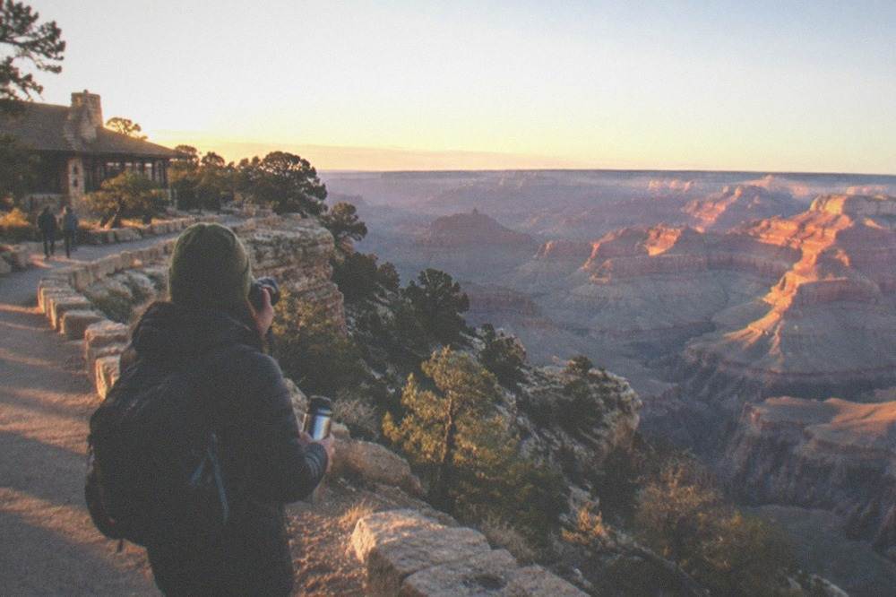 Sunrise light on the layered rock walls of the Grand Canyon with long shadows across the rim
