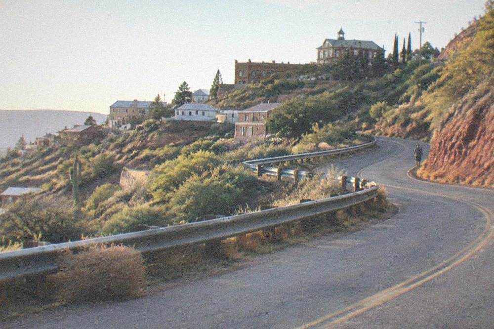 Winding two-lane mountain road climbing toward Jerome through scrub hills