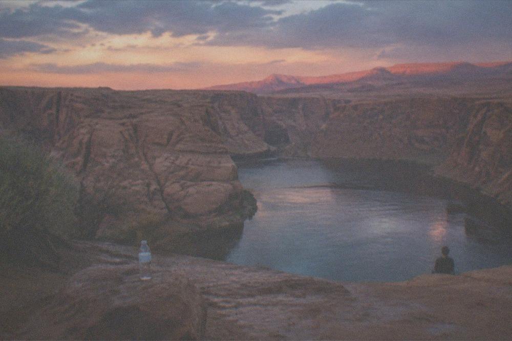 Open water and distant canyon walls glowing in low evening light