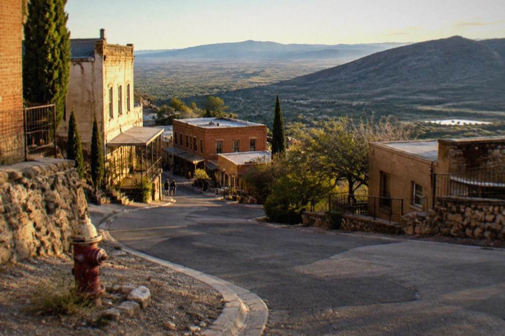 Steep hillside town with historic buildings terraced down a mountainside above a wide valley