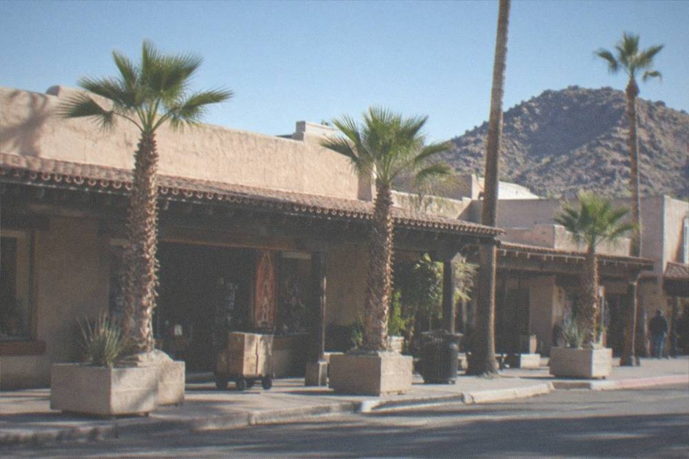 Old Town Scottsdale street with shops and palm trees in late afternoon light