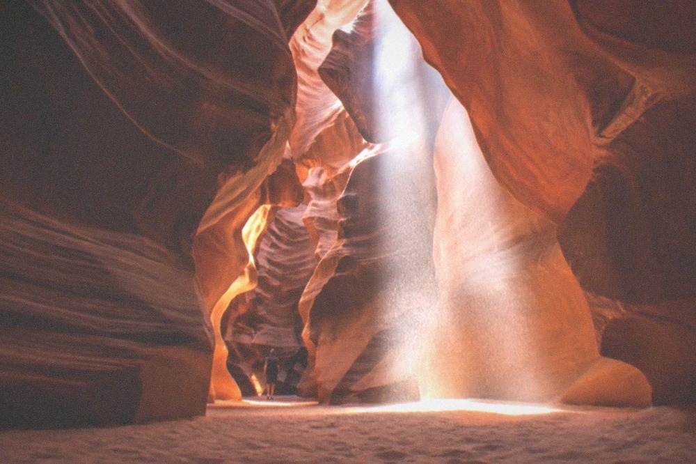 Twisting sandstone slot canyon walls glowing in shafts of light