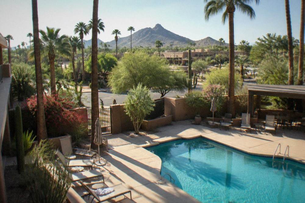 Resort pool and palm trees in central Scottsdale with morning light on the buildings