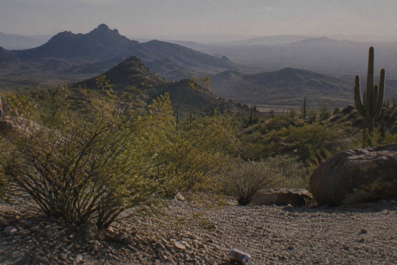 A private tour van parked at a desert overlook, layered mesas and canyon country stretching out ahead.